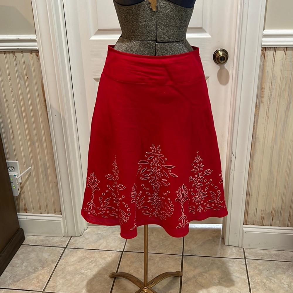 Red A-line skirt with white embroidered design and cute outs.